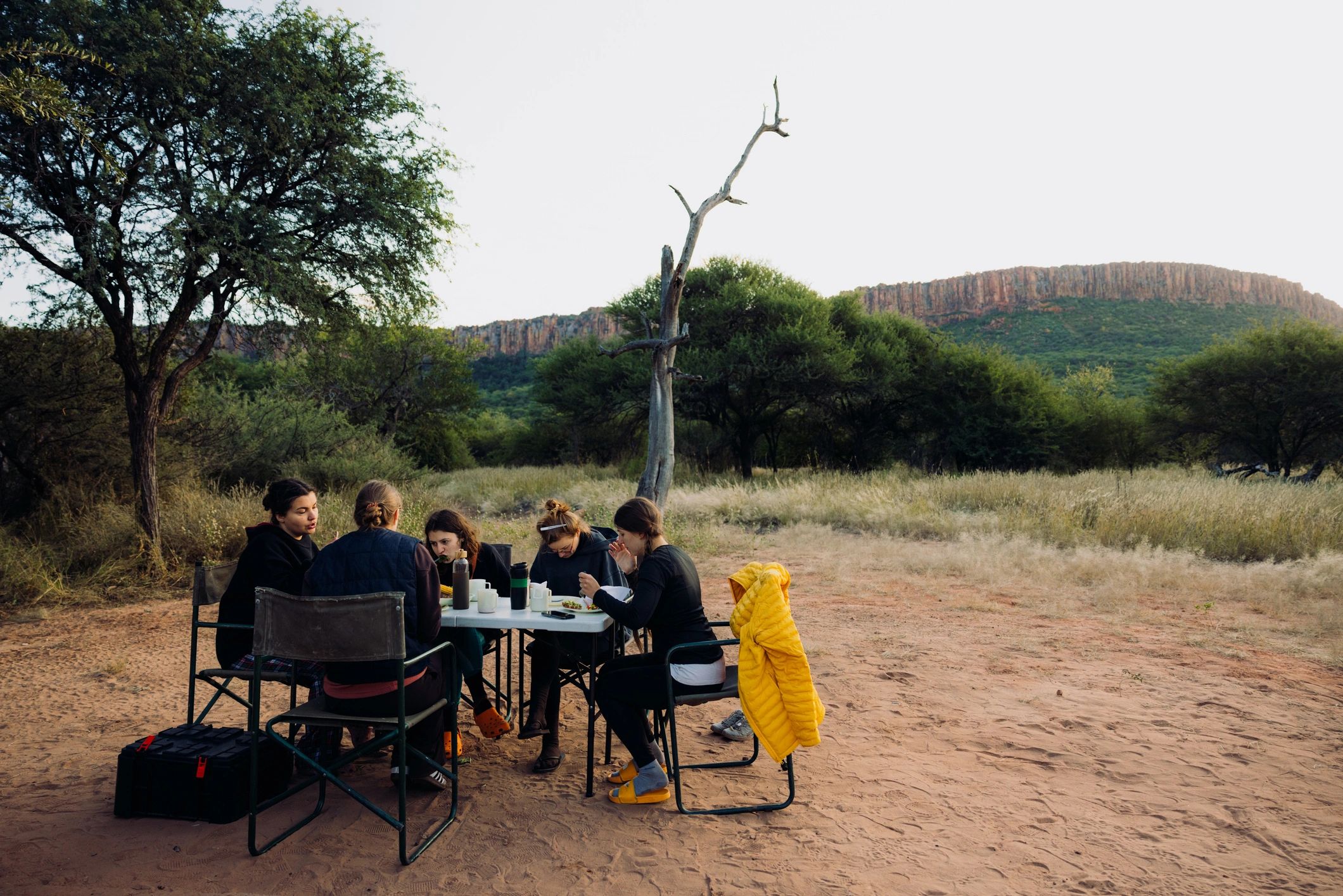 Travelers sharing a relaxed outdoor retreat meal